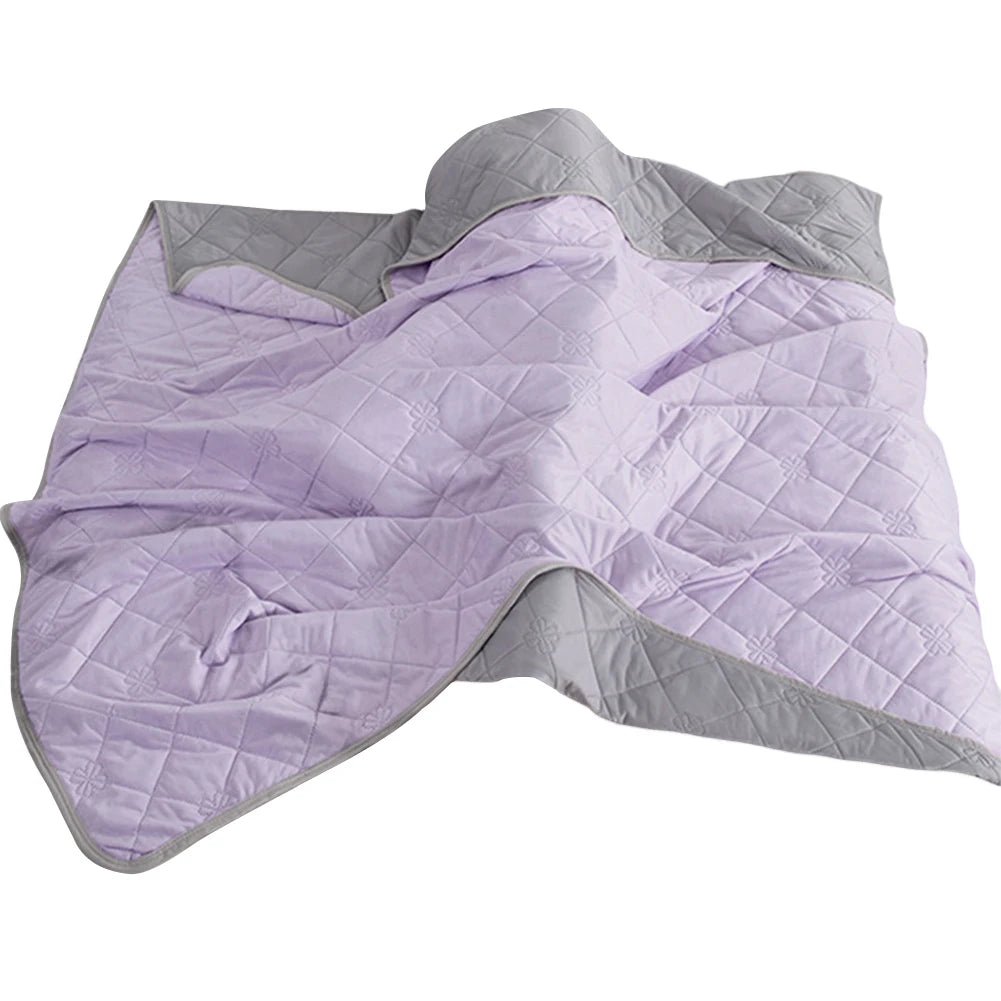 Lightweight cooling blanket spread across a bed