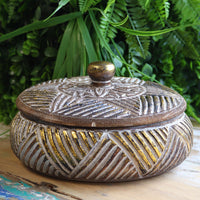 Round wooden gold trinket jewelry box on vanity